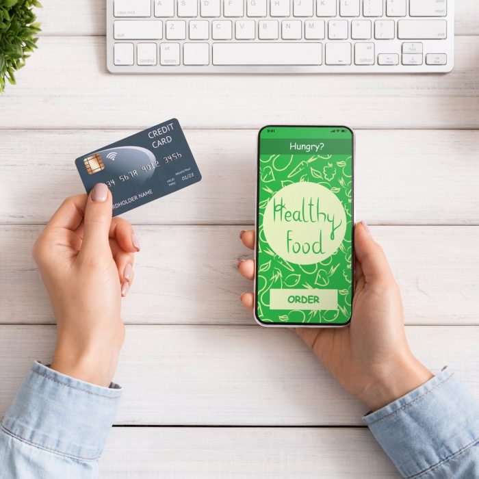 Female hand holding phone with app delivery food on screen